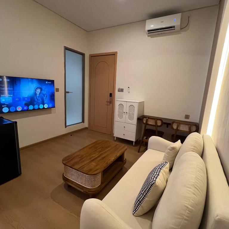 a living room with a white couch and a tv at Casabella Homestay 306 Batam Penuin in Nagoya