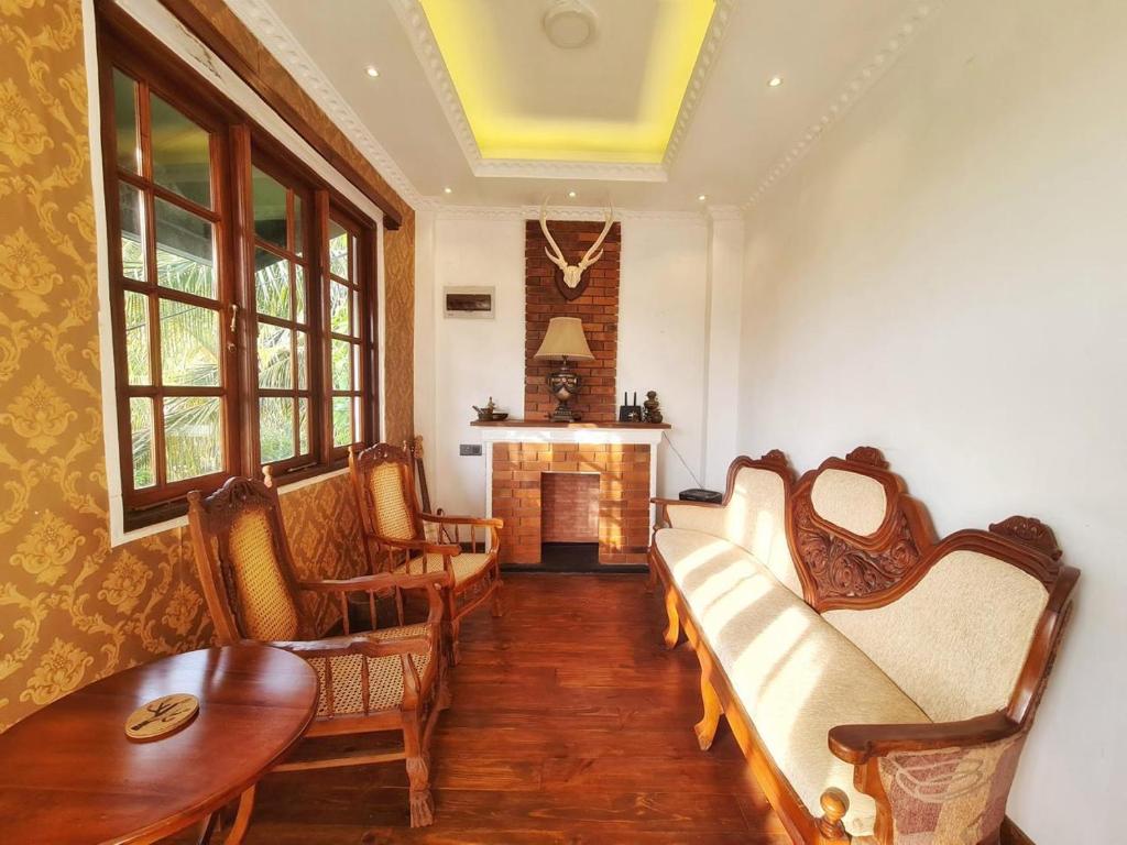 een woonkamer met een bank en een open haard bij Teirack Rosis Wish in Kandy