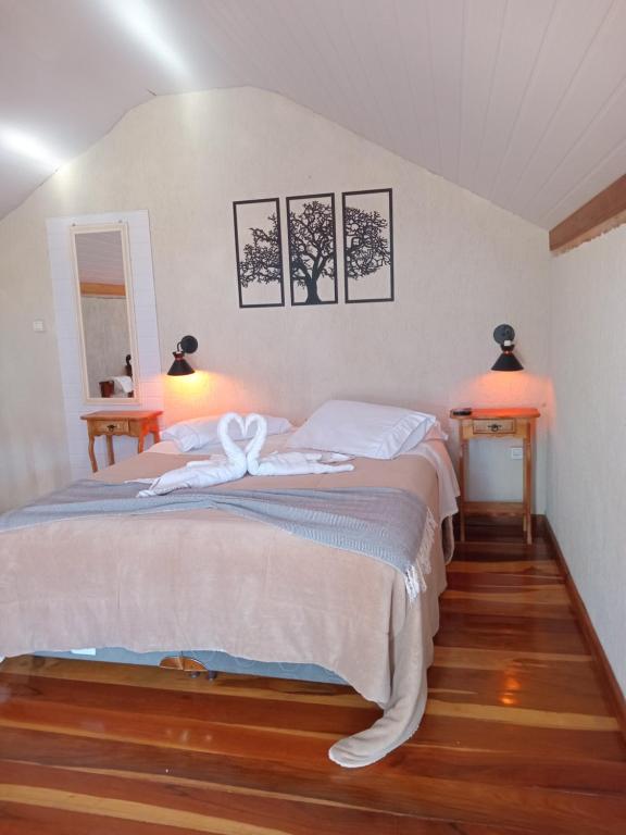 um quarto com duas camas e duas luzes na parede em Cazinha ninho dos canarinhos em Viscode de Mauá