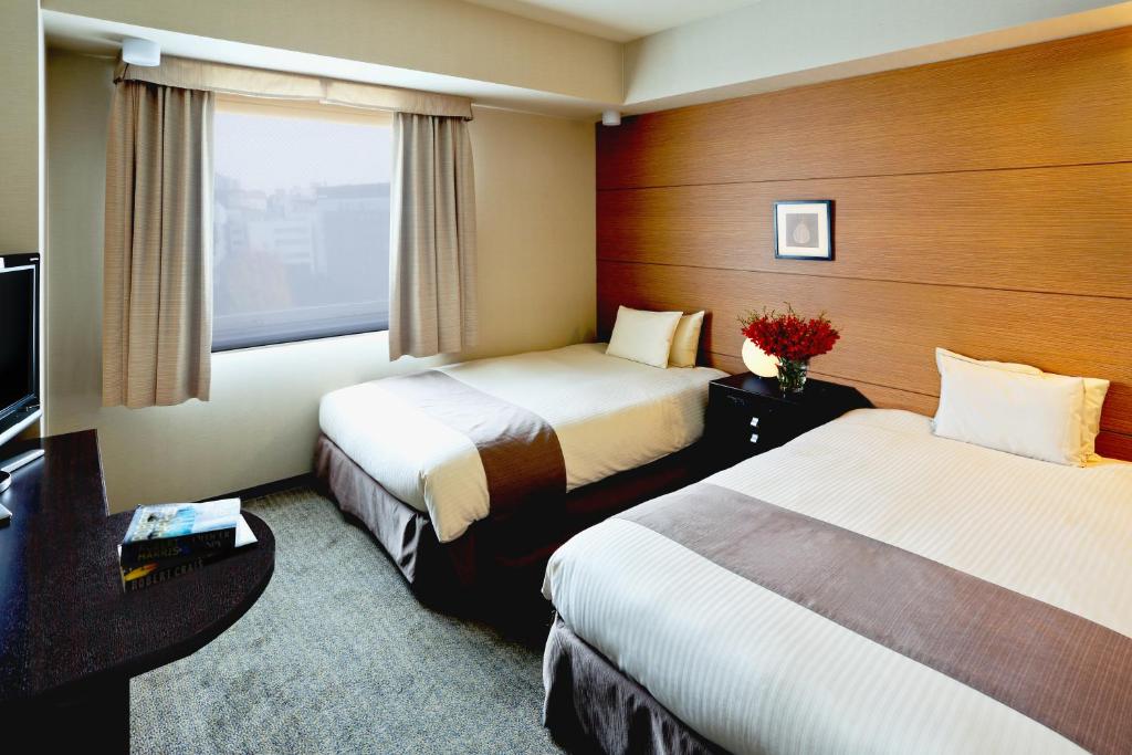 a hotel room with two beds and a window at Citadines Central Shinjuku Tokyo in Tokyo