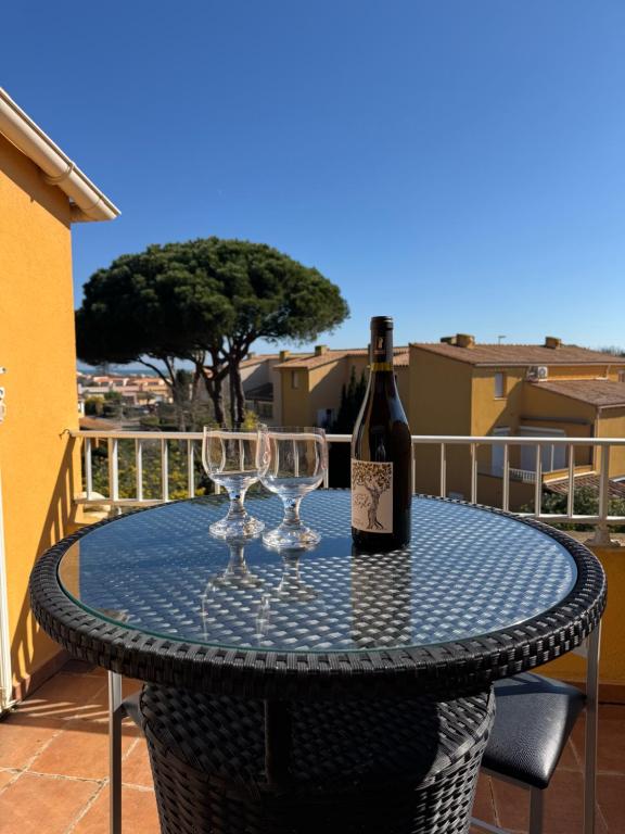 une bouteille de vin et deux verres à vin sur une table dans l'établissement Original -5pers- Histoire de clés, au Cap d'Agde