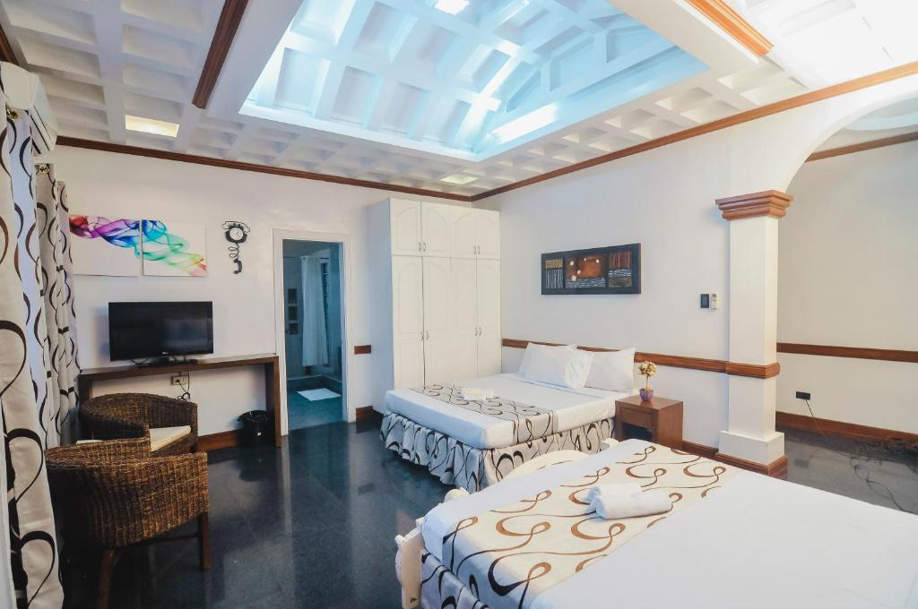 a bedroom with two beds and a skylight at Villa Jhoana Resort in Angono