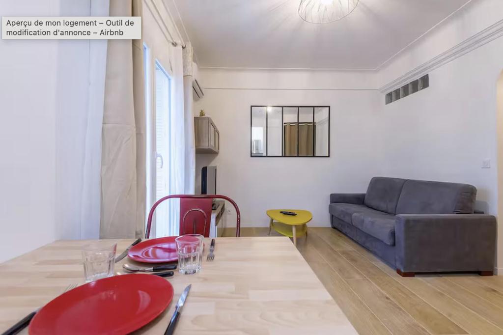 un salon avec une table et un canapé dans l'établissement Charmant studio rue Hérold - Wifi, AC, 2pers, à Nice