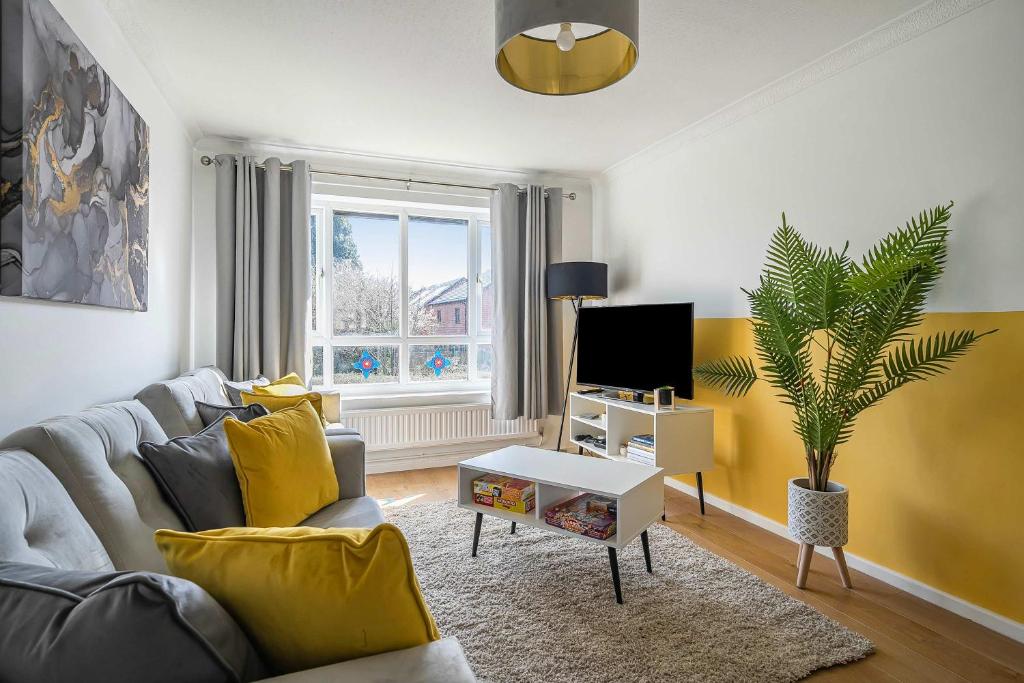 a living room with a couch and a tv at Stylish 2BR Apartment near MCR Airport in Manchester