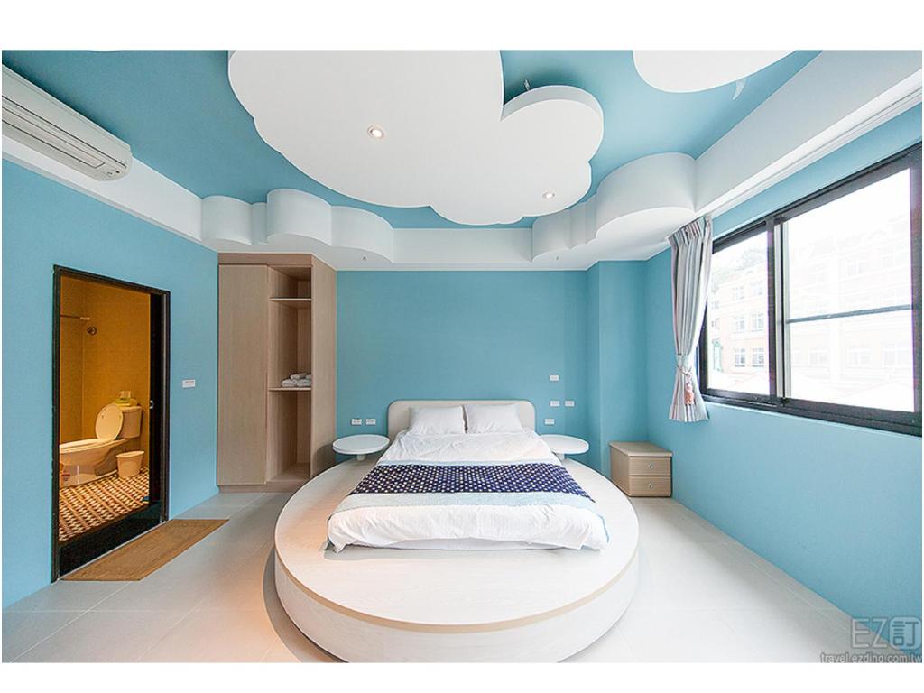 a blue bedroom with a bed with a cloud ceiling at Yellow Kite Hostel in Tainan