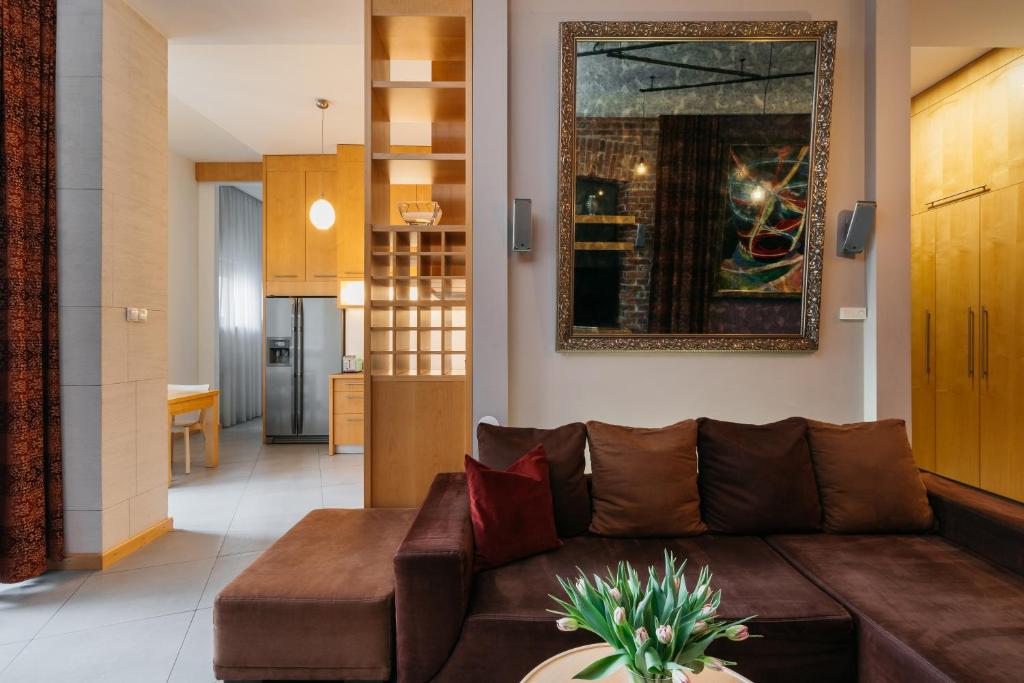 a living room with a brown leather couch at Native Apartments Krupnicza 7 in Kraków