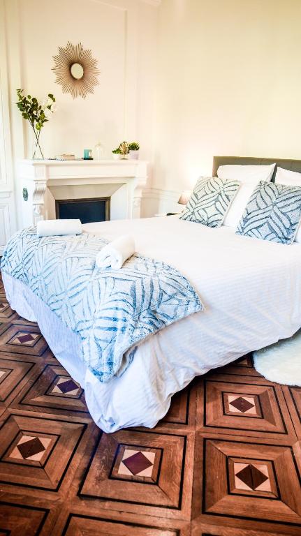 a bedroom with a large bed with a wooden floor at Le Canyon Rouen Centre by MyFrenchPAT Terrasse & Parking in Rouen