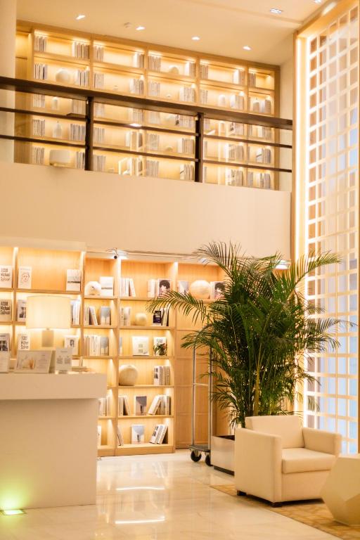 a library with a plant in the middle of a room at Hospes Amérigo, Alicante, a Member of Design Hotels in Alicante