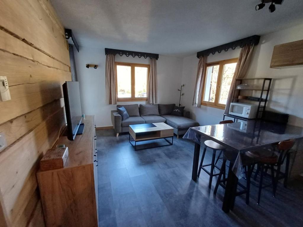 un salon avec un canapé et une table dans l'établissement Appartement 4-6 Personnes - Piscines - SAMOENS - HAUTE SAVOIE, à Samoëns