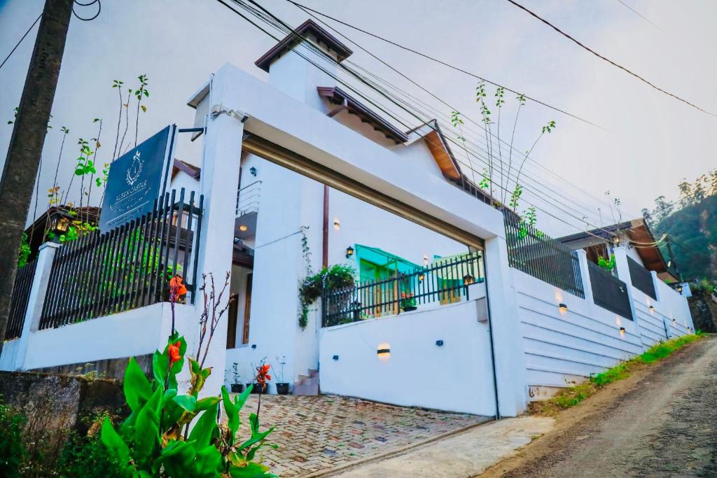 una casa bianca con una grande porta su una strada di Alben Castle Glenfall a Nuwara Eliya
