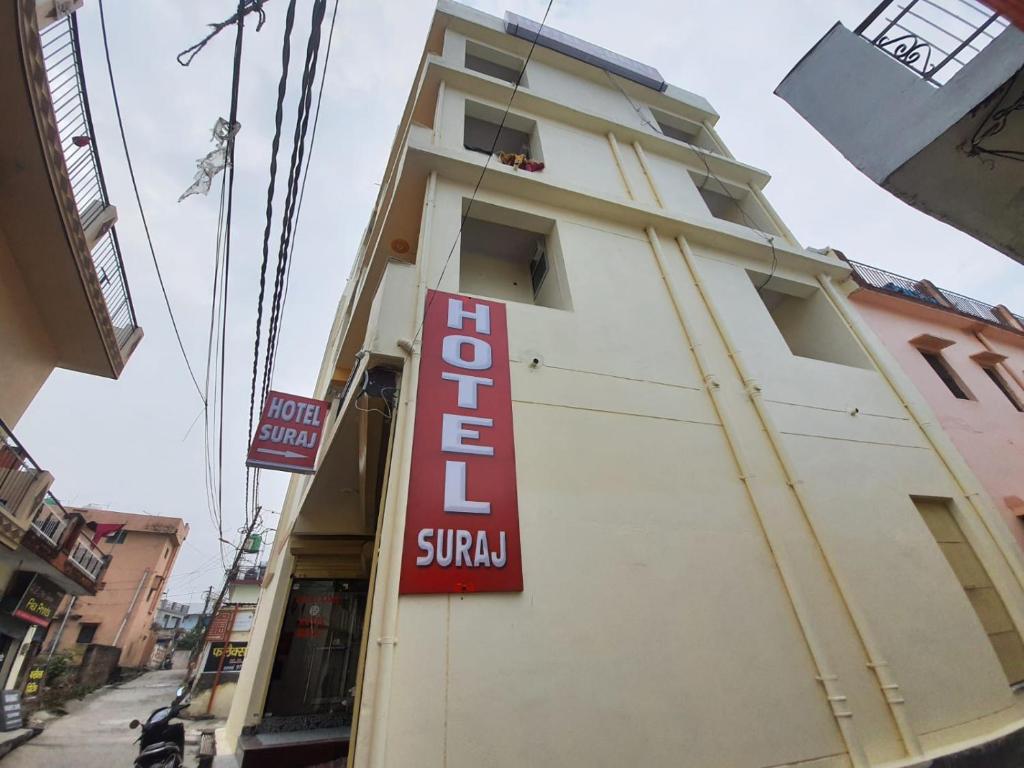 a building with a red sign on the side of it at Hotel Suraj in Rishīkesh