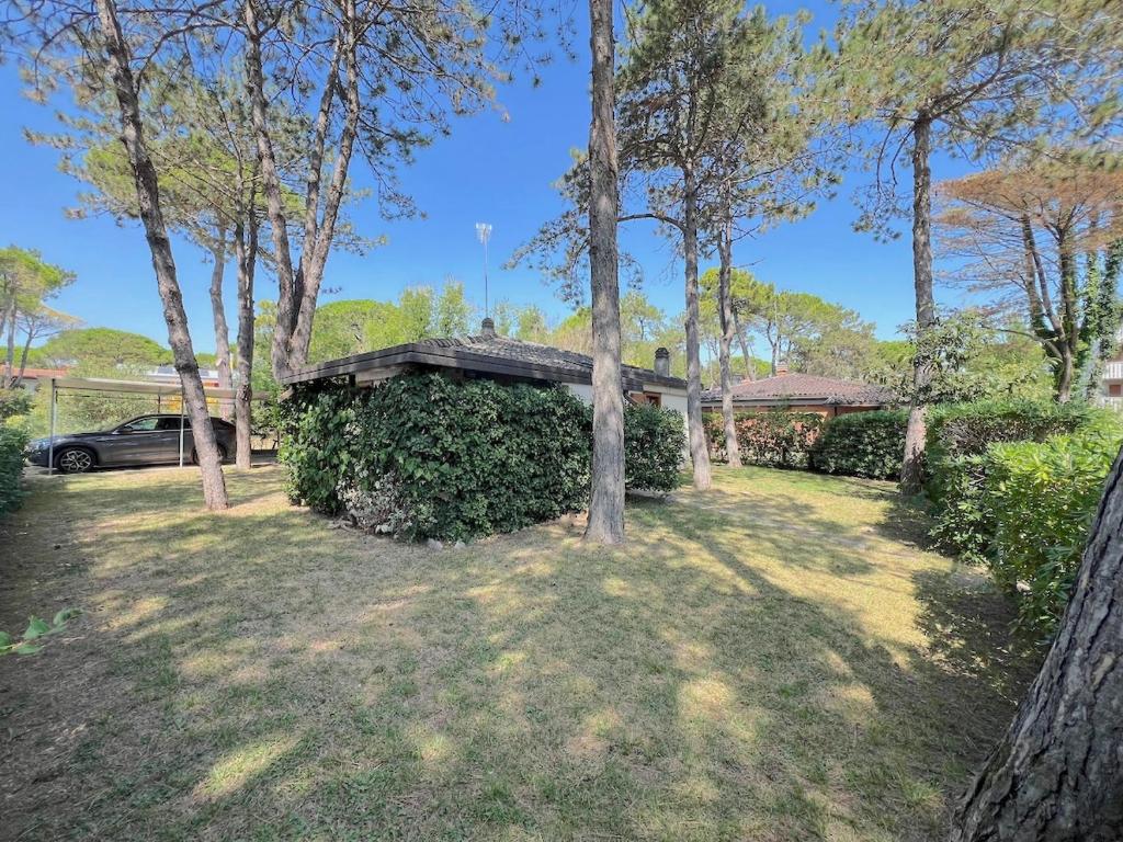 Villa Milly في لينانو سابيادورو: منزل به سياج وأشجار في الفناء