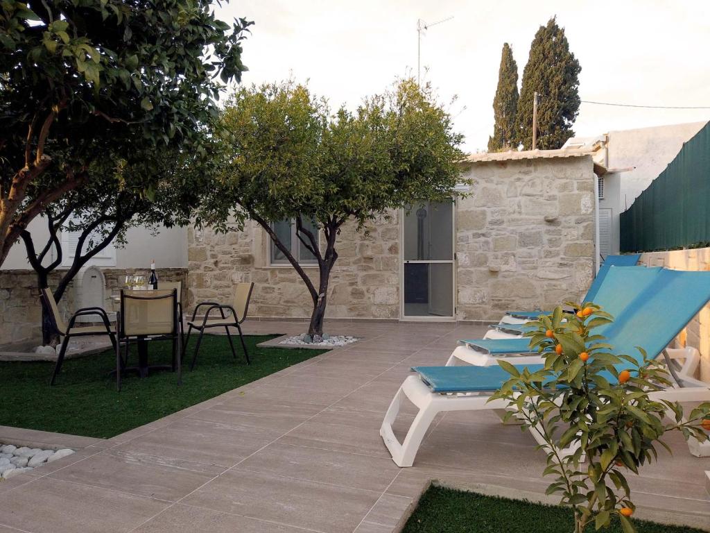 eine Terrasse mit Stühlen und einem Tisch im Hof in der Unterkunft Marina's Cottage in Lagolíon