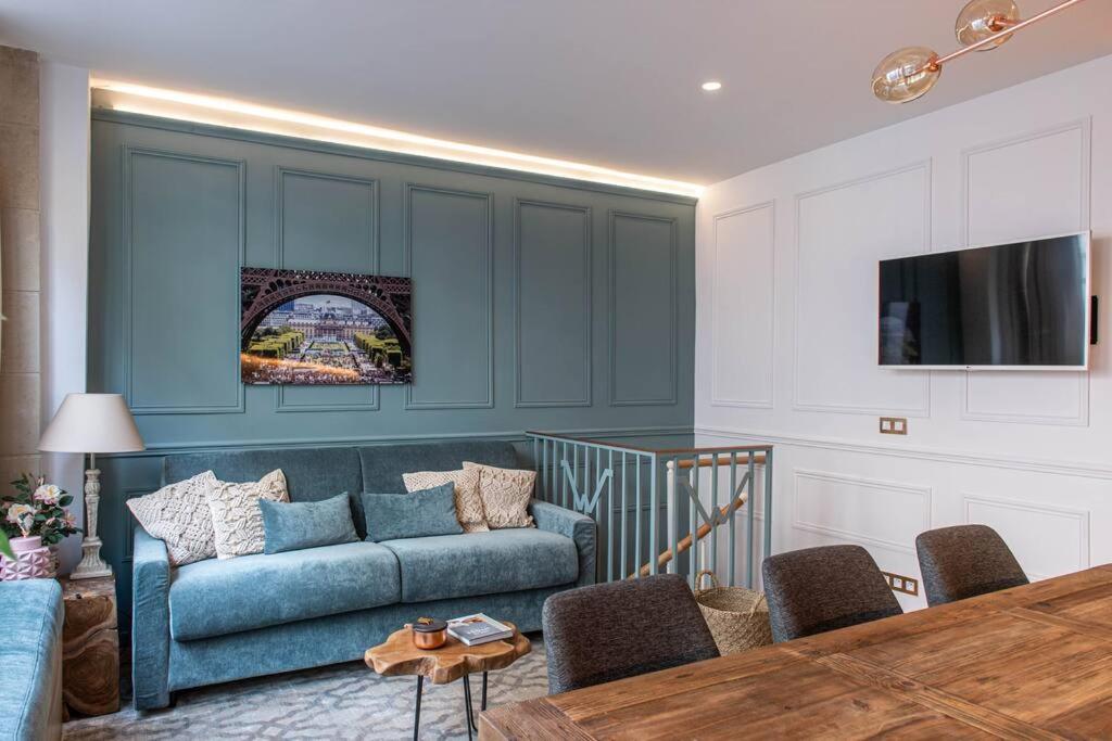 ein Wohnzimmer mit einem blauen Sofa und einem Tisch in der Unterkunft My Cottage in Paris in Paris