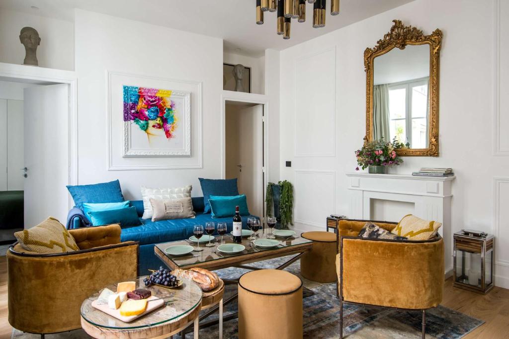 un salon avec un canapé bleu et une table dans l'établissement My Opéra II, à Paris