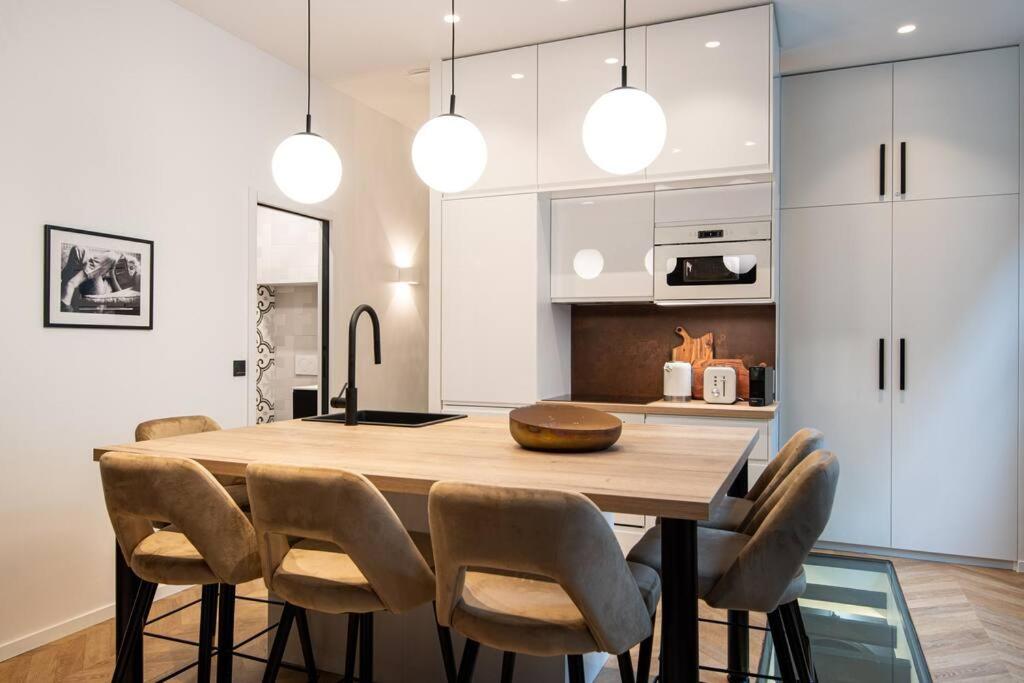 une cuisine avec une table et des chaises en bois dans l'établissement La librairie parisienne-Convention, Porte de Versailles, à Paris