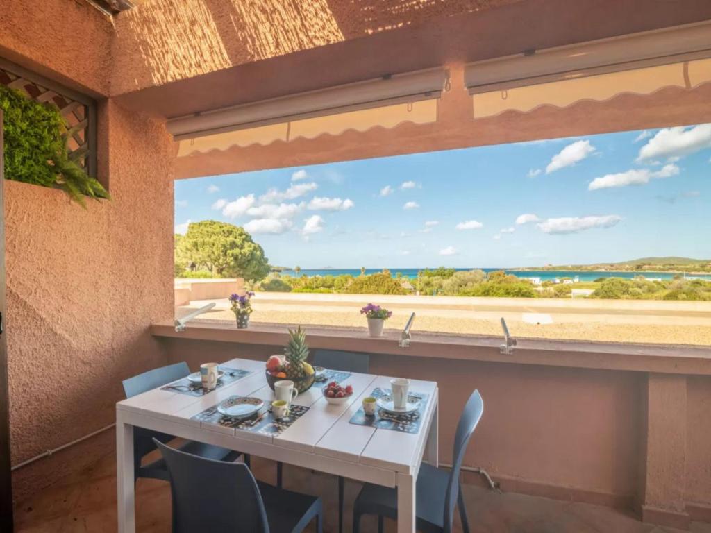 Un comedor con una mesa y un gran ventanal. en True paradise with a splendid panoramic terrace, en Porto Rotondo