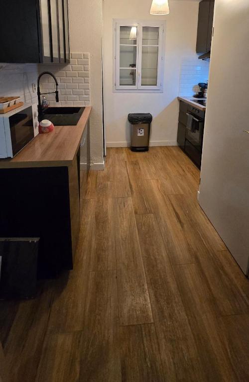 Il comprend une cuisine dotée de parquet et d'un comptoir. dans l'établissement 3 Bedroom House - Disneyland Paris, à Magny-le-Hongre