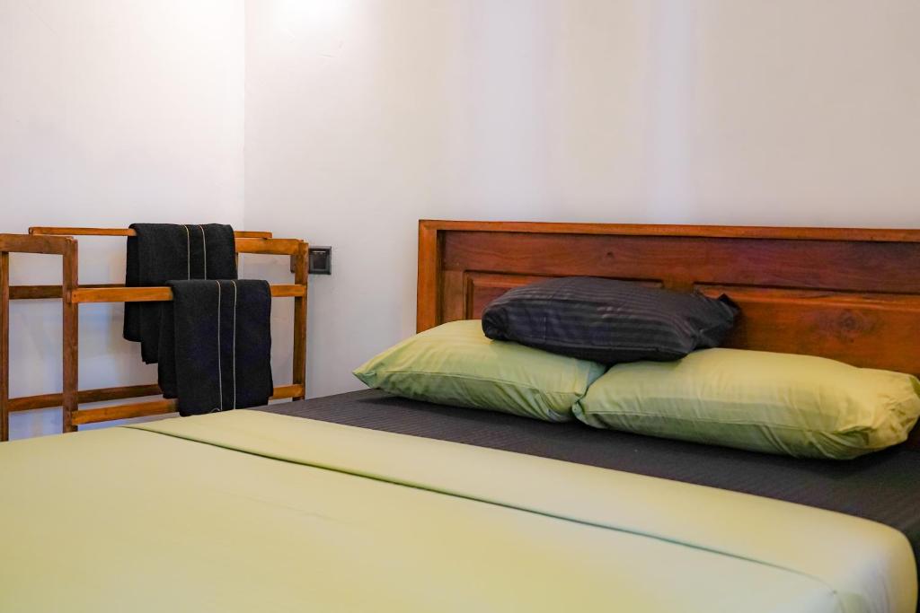 a bedroom with a bed with a wooden head board at Palm & Wild Hiriketiya in Dickwella