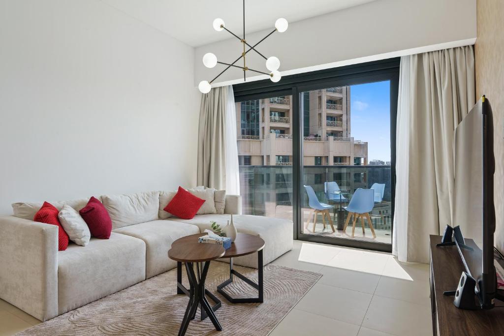 a living room with a couch and a large window at Stylish 1 Br In Downtown Near Burj Khalifa in Dubai