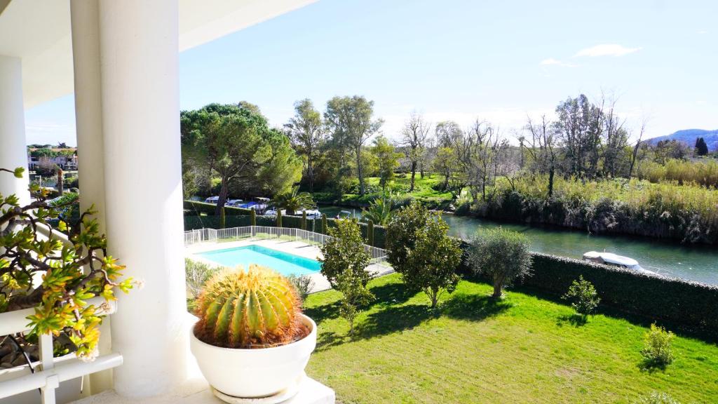 - un balcon avec vue sur la rivière et un cactus dans l'établissement T3 avec vue sur la rivière, piscine, by Palmazur, à Mandelieu-la-Napoule