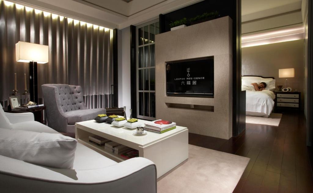 a living room with a white couch and a tv at Leofoo Residences in Taipei