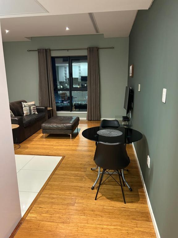 ein Wohnzimmer mit Tisch und Couch in der Unterkunft Lofty-Space in Gaborone