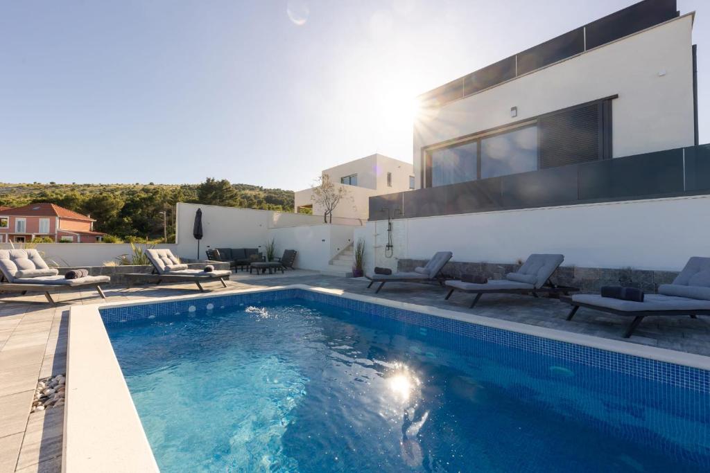 ein Swimmingpool im Hinterhof eines Hauses in der Unterkunft Villa Vista Adriatica in Donji Seget