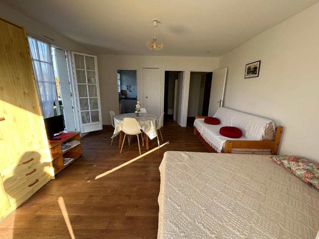 une chambre avec un lit et une table dedans dans l'établissement Studio lumineux au centre-ville avec balcon - FR-1-541-133, à La Roche-Posay