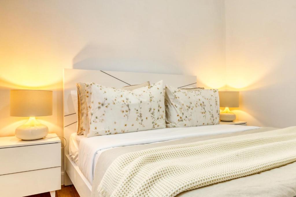 ein Schlafzimmer mit einem weißen Bett mit zwei Lampen in der Unterkunft Casa do Pinheiro I, a Home in Madeira in São Vicente