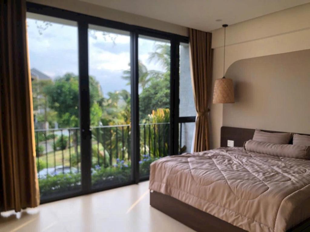 a bedroom with a bed and a large window at Gia Hân Villa in Cam Thanh