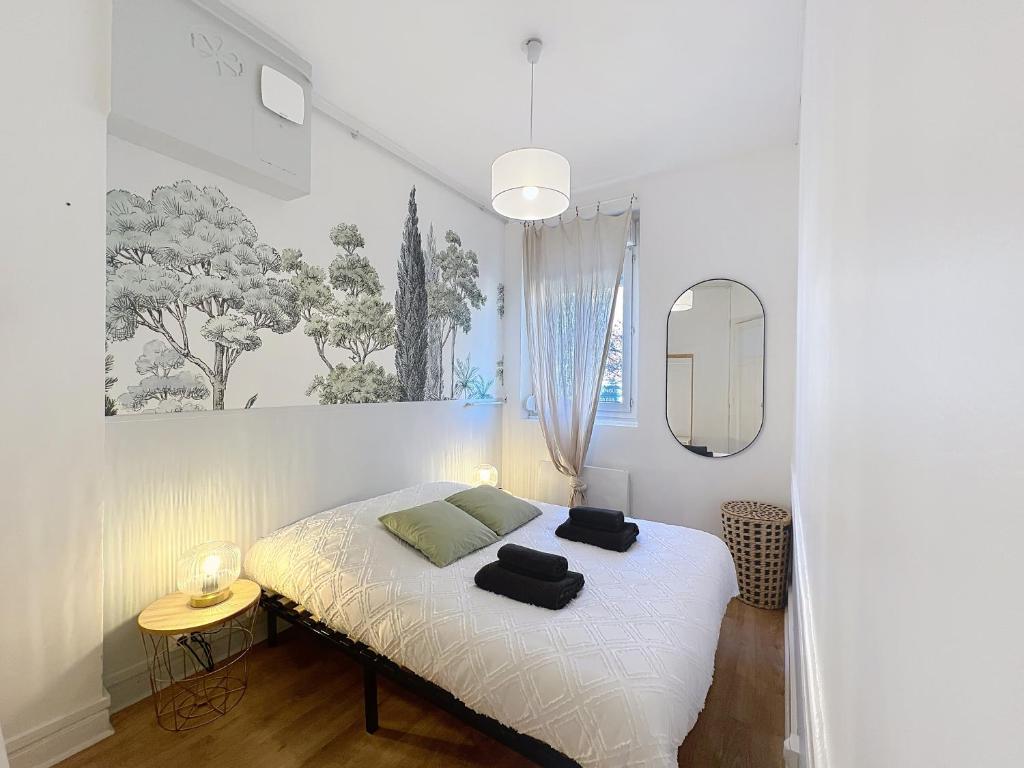 une chambre avec un lit avec deux serviettes dessus dans l'établissement Vesle- Hyper Centre - 2 Chambres, à Reims