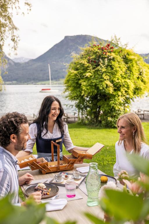 a group of people sitting around a picnic table at Hotel Seevilla Wolfgangsee in St. Wolfgang