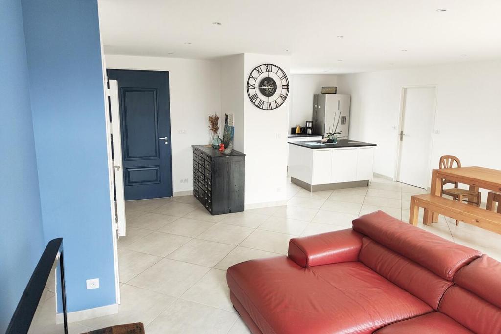 un salon avec un canapé rouge et une cuisine dans l'établissement Maison MANGUELI - Bassin d 'Arcachon, à Audenge