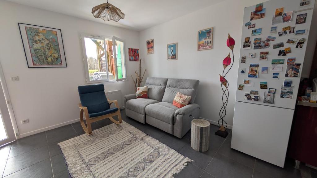 un salon avec un canapé et une chaise dans l'établissement Appartement avec jardin proche de l'océan, à Saint-Julien-en-Born
