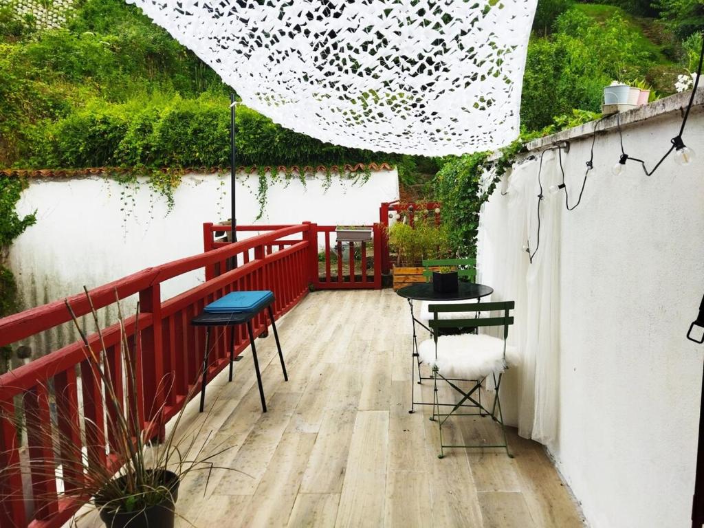 - un balcon avec une balustrade rouge, une table et des chaises dans l'établissement Appartement cosy au cœur du village historique, à Saint-Jean-Pied-de-Port