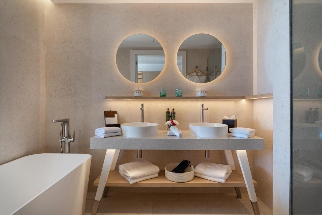 a bathroom with two sinks and a tub and mirrors at The View Agadir in Agadir