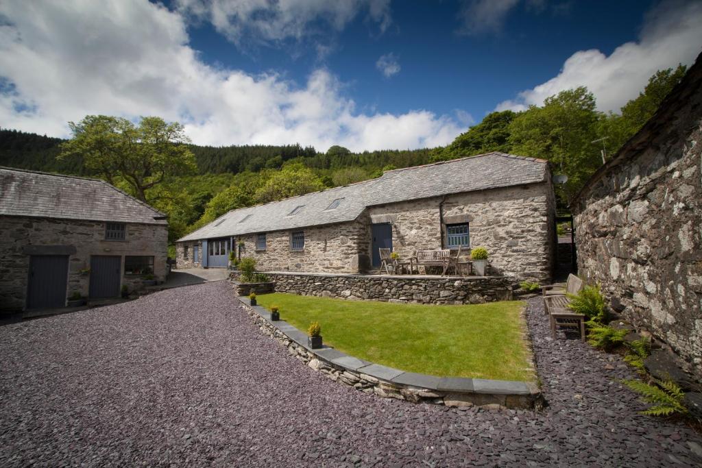 a group of stone buildings with a gravel driveway at Plasglasgwm in Betws-y-coed