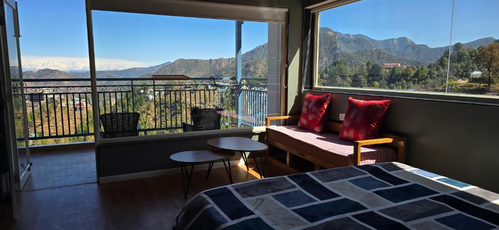 a bedroom with a bed and a balcony with a view at The Pluck Homestay- Umagarh in Rāmgarh
