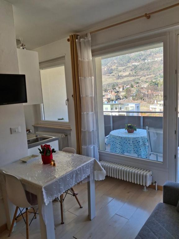 a living room with a table and a large window at Merano Panoramablick ruhig gelegen in Merano
