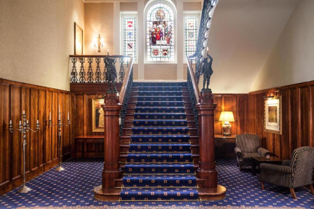 a staircase in a building with a stair case at Exeter Rougemont Station Experience By Palette Resorts in Exeter