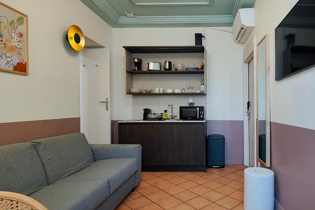 a living room with a couch and a kitchen at Aparthotel AMMI Vieux Nice in Nice