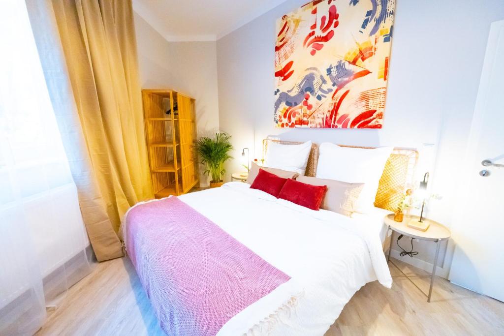 ein Schlafzimmer mit einem weißen Bett mit roten Kissen in der Unterkunft BetterBeds Essen in Essen