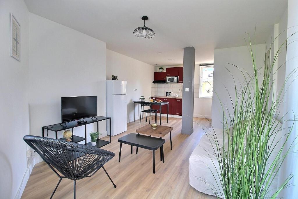 un salon avec un canapé et des chaises et une cuisine dans l'établissement Duplex rénové - Proche centre-ville, à Bourges