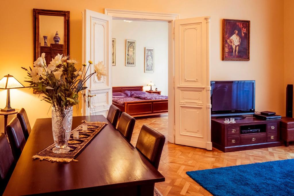 een woonkamer met een eettafel en een televisie bij Apartment Vodičkova 11 in Praag