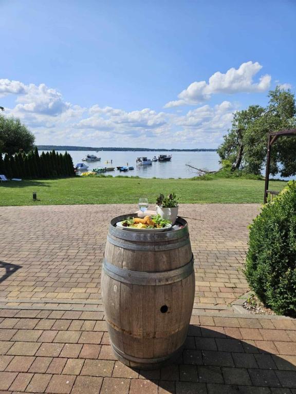 a wooden barrel with a bowl of food in it at Noce i Dnie in Pierkunowo