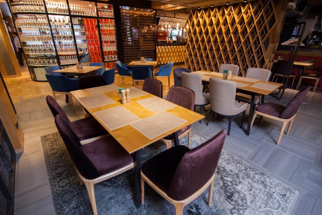 a restaurant with wooden tables and chairs at AZIMUT Hotel Siberia in Novosibirsk