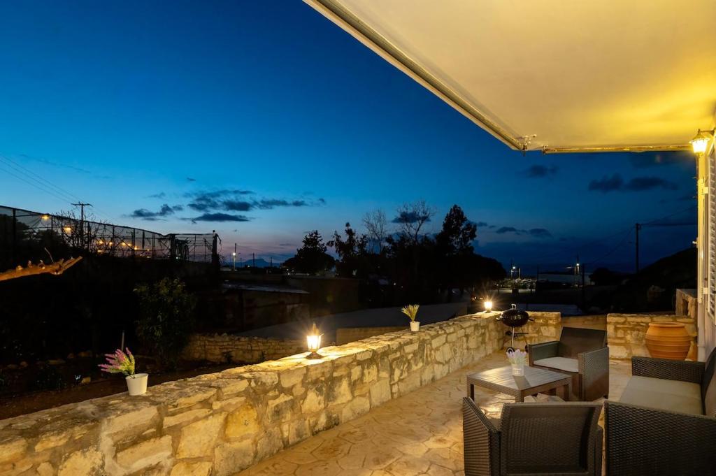 a patio with a stone wall at night at Casa Di Aspa in Rethymno Town