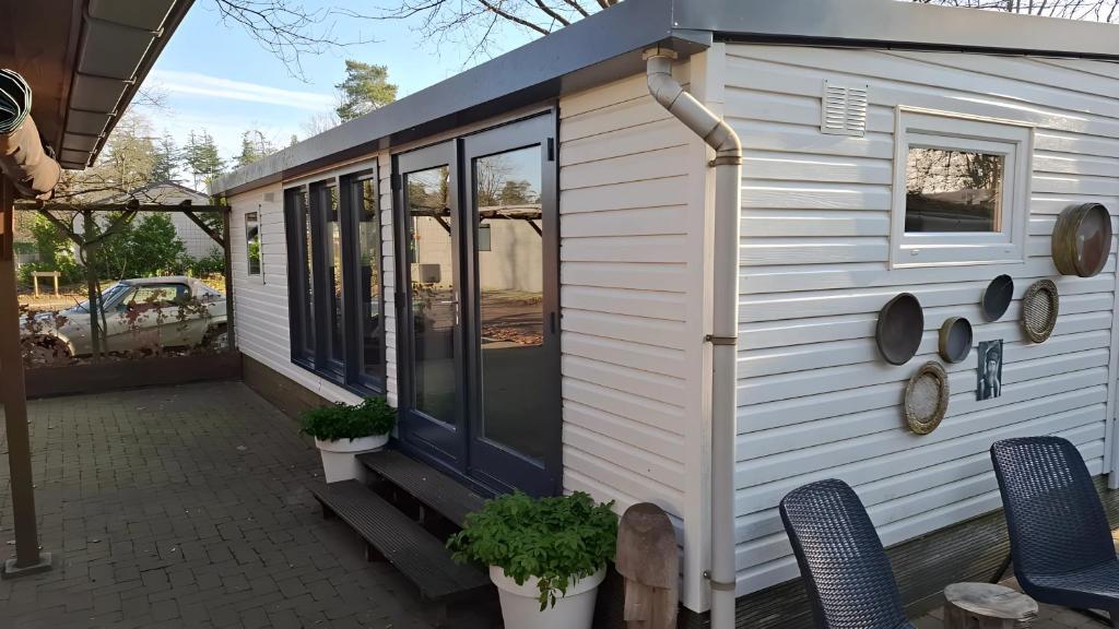 ein kleines Haus mit einer Veranda und Fenstern in der Unterkunft La Casa Di Nyo - Camping De Schatberg in Sevenum