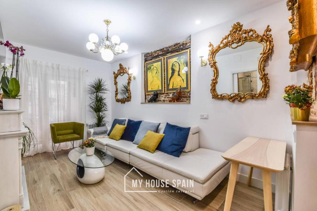 salon z kanapą i lustrem w obiekcie MyHouseSpain - Sensacional piso en Malasaña w Madrycie